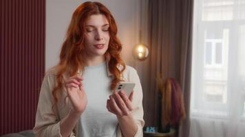 Happy joyful Caucasian woman looking mobile phone device swipe screen at home. Satisfied positive emotion female lady smile enjoying online scrolling feed web girl chatting playing virtual game video