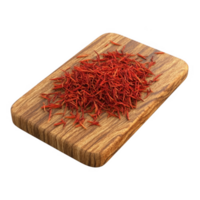 Vibrant saffron strands displayed on a wooden cutting board, showcasing its rich color. png