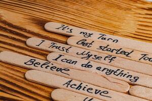 Positive thoughts for increasing selfesteem on wooden posts on wooden background photo