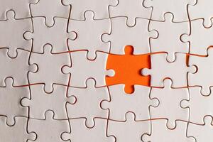 Conceptual photo of a puzzle, missing piece, on an orange background
