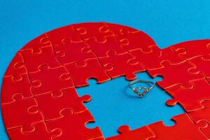 Love concept. Broken heart puzzle with wedding ring, missing puzzle pieces photo