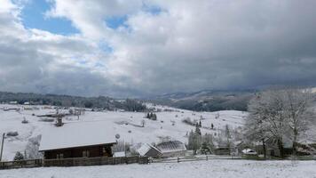Time lapse of Clouds move over the mountains and the village in winter. video