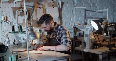 Craftsman using sewing machine in workshop video