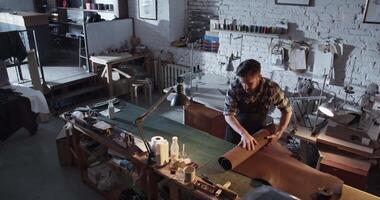 Male artisan preparing leather for work video