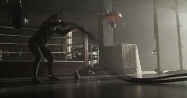 Powerful female athlete exercising with battle ropes in gym video