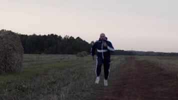 deportista corriendo en campo con pajar en noche video