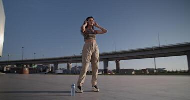 Young woman listening to music on street video