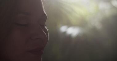 Smiling sensual female harpist opening eyes while preparing for performance video