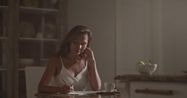 Smiling female composer writing in notebook while composing music video