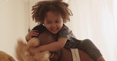 Cute black toddler hugging dad while having fun together video