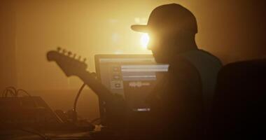 Man in cap playing rock music on guitar in studio video