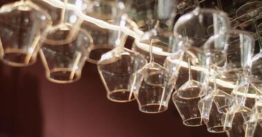 Wine glasses hanging on rack in bar video
