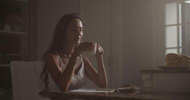 Sensual female musician drinking coffee while composing lyrics video