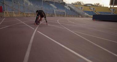 Female runner at starting block getting ready before run video