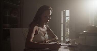 Smiling female composer writing in notebook while composing music video