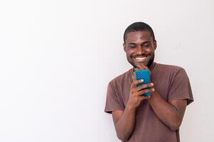 black African american guy holding big smartphone with white blank screen in hand, showing close to camera and pointing at the phone. photo