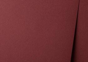 Luxury paper texture in deep marsala and brick red hues. Matte and grainy surface with a rich, photo