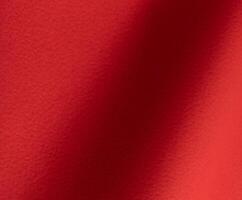 Rich scarlet paper texture with a grainy, perforated surface and soft gradients of crimson and ruby photo