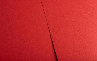 Deep crimson paper texture with a smooth yet grainy surface and subtle perforations. The vibrant, photo