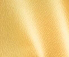 Gold glossy paper background. Shiny and smooth surface with a shimmering texture, perfect for photo