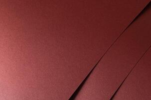 Burgundy red metallic satin paper texture with a pearlescent shimmer. The warm red-brown tones and photo