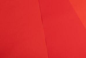 Scarlet red paper background with a smooth, vibrant gradient and fine monochrome texture. Minimalist photo