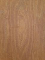 a wooden surface featuring a natural wood grain pattern. The wood has a medium-brown tone with visible horizontal lines, small nail marks, and subtle texture, giving it a raw and organic appearance. photo