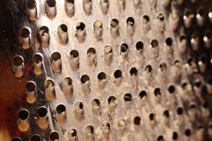 This is a CloseUp of a Grater Surface featuring multiple holes that serve a purpose photo