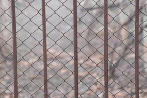 A Rusty Chain Link Fence stands against a Beautifully Blurred Background that captivates viewers photo