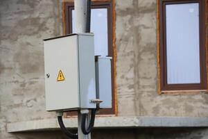 The electrical box is located on the utility pole, which is positioned near the windows photo