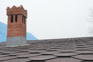 A Charming Brick Chimney on a Rooftop, adding character and warmth to the skyline view photo