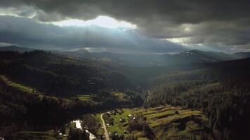 Aerial view of storm clouds and a village in the Carpathian Mountains. Beautiful landscape. 4K video