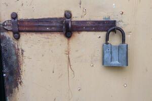 A Rusty Lock and Latch Attached to a Vintage Door, Highlighting Interesting Details and Design photo