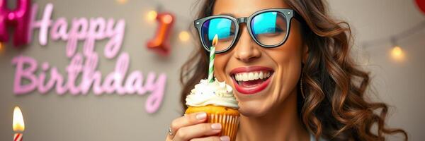 Joyful celebration with a smiling woman enjoying a cupcake during a birthday party in a decorated venue photo