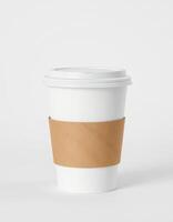 White disposable coffee cup with a kraft paper sleeve on a plain background during morning hours photo