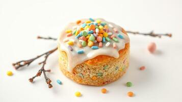 Colorful dessert with frosting and sprinkles on a white background garnished with small colorful candies photo