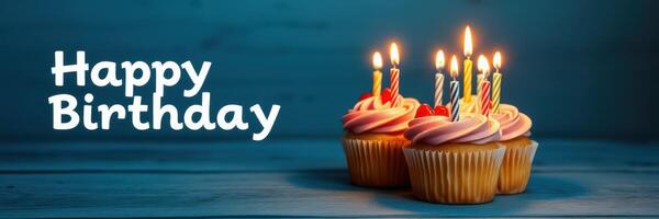 Celebrate a joyful birthday with decorated cupcakes and lit candles on a vibrant blue background photo