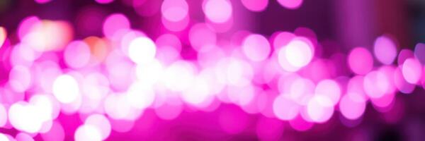Bright pink bokeh lights create a festive atmosphere at a lively nighttime celebration in the city photo
