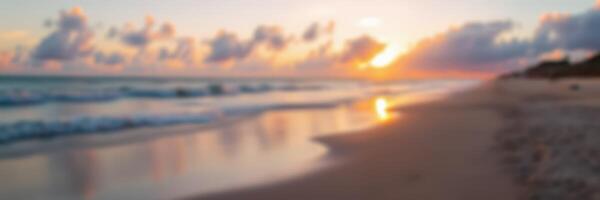 Sunset over tranquil beach with soft waves and colorful clouds in the evening sky photo