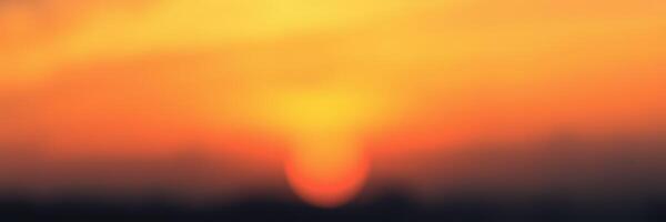 Sunset over the horizon creating a beautiful blend of orange and yellow colors in the evening sky photo