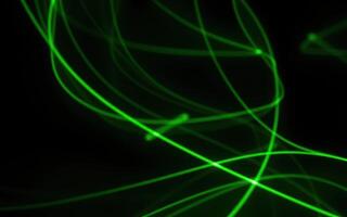 Vivid green light trails create dynamic patterns against a dark background in an abstract display of energy and motion photo