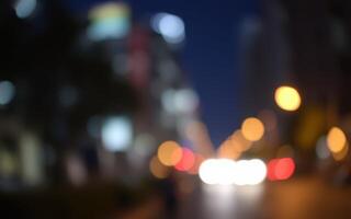 City lights illuminate a blurred urban street at night, showcasing the vibrant energy of the city after dark photo