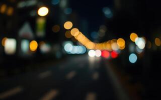 Evening city lights blend in vibrant bokeh style along a busy street filled with cars and urban energy photo