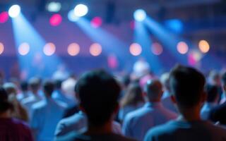 Lively crowd enjoying a concert with colorful stage lights in the background during an evening event photo
