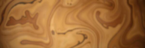 Swirling patterns of warm beige and brown create an abstract design reminiscent of natural wood grain photo