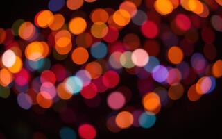 Colorful bokeh lights illuminating a dark background during a festive celebration at night in a lively environment photo