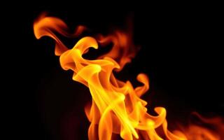 Bright flames dance in the dark, creating a warm and mesmerizing glow during a cool evening photo