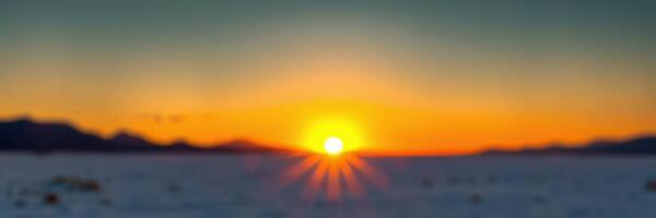 Vibrant sunset illuminating the horizon over a snowy landscape at dusk photo