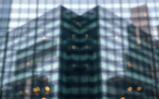 Urban reflection of modern skyscraper on glass surface showing artistic geometric patterns in cityscape photo