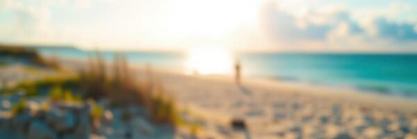 Golden sunset over ocean with person walking on the beach during twilight hours in a tropical paradise photo